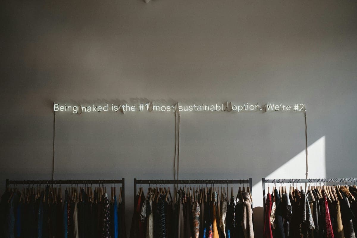 A neon sign reading "Being naked is the